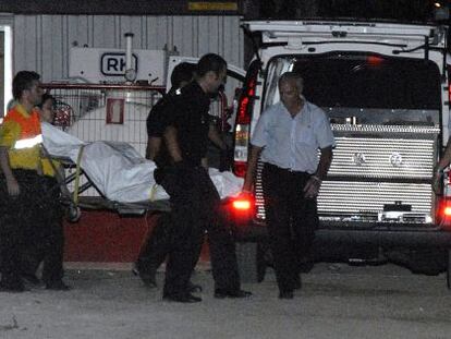 Policías y funerarios trasladan el cuerpo del trabajador fallecido.