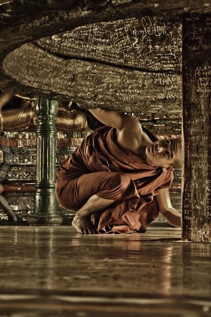 Un monje budista observa el texto del interior de una campana gigante en Rangún, Myanmar.