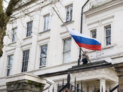 Un hombre recoloca la bandera de Rusia en el consulado ruso de Londres este mi&eacute;rcoles 14 de marzo. 