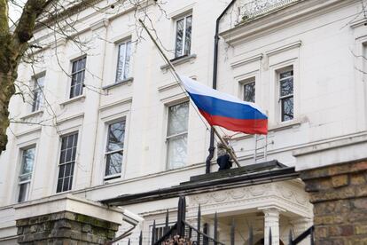 Un hombre recoloca la bandera de Rusia en el consulado ruso de Londres este mi&eacute;rcoles 14 de marzo. 