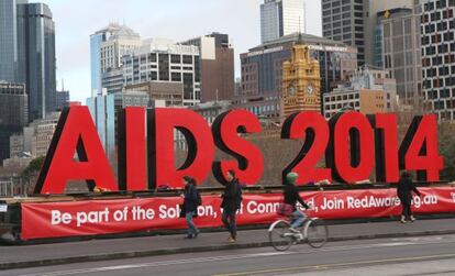 Cartaz em Melbourne, onde se realiza a conferência mundial da Aids. Pessoas deixam flores em homenagem aos 100 especialistas que morreram no voo da Malaysia Airlines, que caiu na Ucrânia.