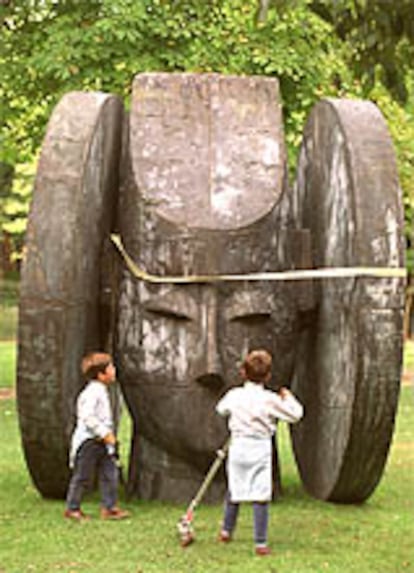 Dos niños observan <i>La dama</i>, de Manolo Valdés, expuesta en el Retiro.