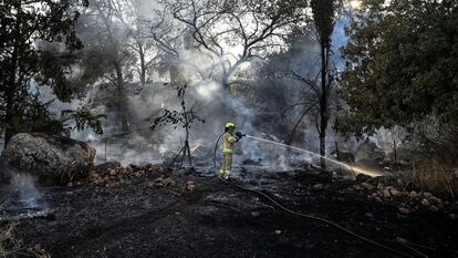 Un bombero israelí trata de apagar un incendio tras el ataque.