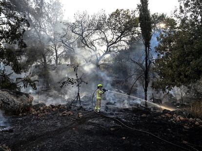 Un bombero israelí trata de apagar un incendio provocado por el ataque de Hezbolá, este jueves cerca de la frontera con Líbano.