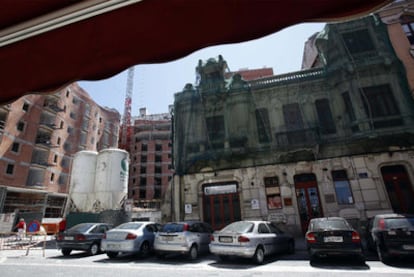 El edificio modernista protegido de A Coruña, cubierto por una red. Al fondo, la nueva edificación que lo amenaza.
