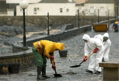 Trabajadores de la empresa pública Tragsa limpian la nueva oleada de fuel del <b></b><i>Prestige</i> llegada a Muxía (A Coruña).