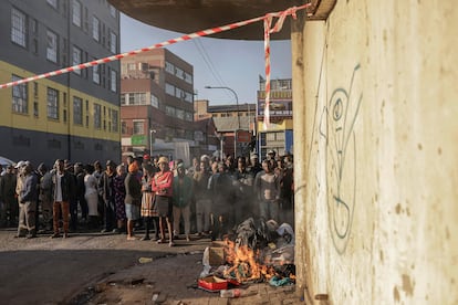 Vecinos siguen de cerca las labores de extinción del inmueble afectado por el incendio en el centro de Johannesburgo, este jueves. 