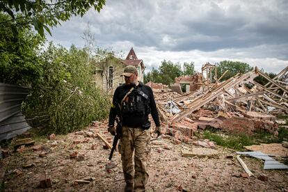 Un combatiente de las Fuerzas de Defensa Territorial, frente a un edificio bombardeado en las afueras de la provincia de Donetsk, en Donbás.