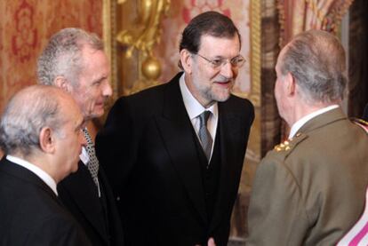 Jorge Fernández Díaz, Pedro Morenés y Mariano Rajoy conversan con el Rey durante la recepción de la Pascua Militar.