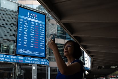 Una mujer junto a los paneles exteriores de la Bolsa de Hong Kong.