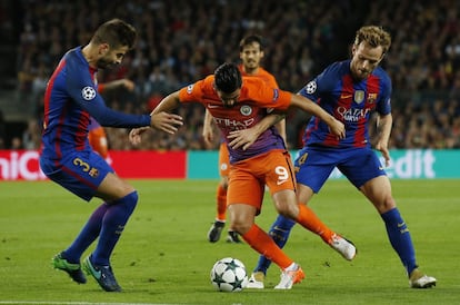 Nolito (centro) del Manchester City presionado por Ivan (derecha)del Barcelona.