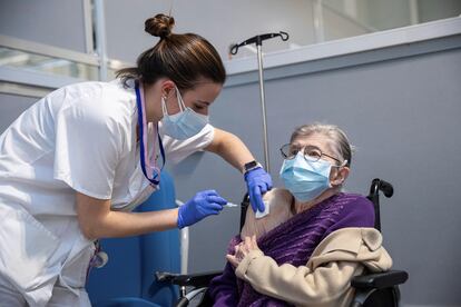 Una profesional sanitaria vacuna a una mujer durante la vacunación de los mutualistas de Muface, Isfas y Mugeju, en marzo en Madrid.