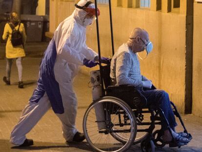 A health worker wheels a coronavirus patient into a hospital in Barcelona at the peak of the pandemic.