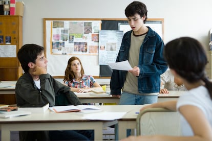 Un alumno lee un trabajo al resto del aula.