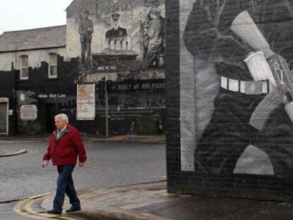 Un hombre camina junto a un mural con paramilitares pintados en Belfast, el lunes. 