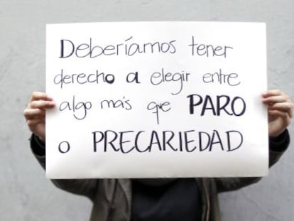 Un estudiante posa con un cartel sobre el desempleo juvenil.