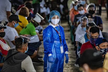 Un sanitario con ropa de protección controla la cola de acceso a un centro sanitario para hacer pruebas de coronavirus a conductores de transporte público en Manila. Filipinas sigue siendo el país más afectado por la pandemia en el sudeste asiático, con 324.762 casos confirmados y 5.840 muertes.