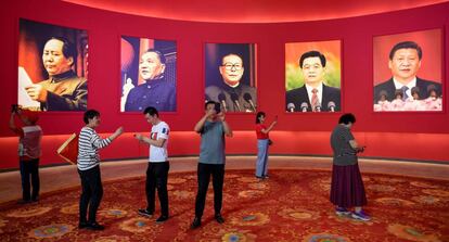 Un grupo de personas fotografía una exposición por el 70º aniversario de la República Popular de China con los retratos (de izquierda a derecha) de Mao Zedong, Deng Xiaoping, Jiang Zemin, Hu Jintao y el presidente actual, Xi Jinping, ayer en Pekín.