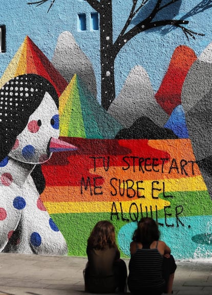 Pintada contra la gentrificación sobre un grafiti de Okuda, en la calle de Embajadores de Madrid.