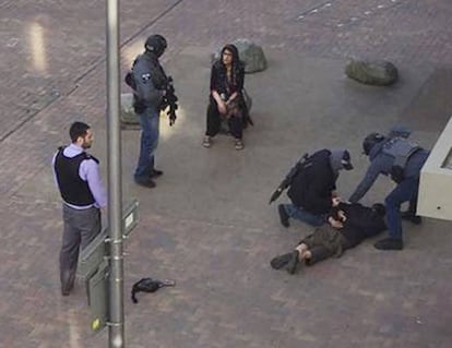 Un hombre permanece en el suelo mientras le colocan las esposas tras ser detenido en los apartamentos Elizabeth Fry en Barking, al este de Londres.