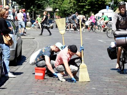 Vecinos de Hamburgo limpian las calles despu&eacute;s de los destrozos causados por las protestas del G-20. 