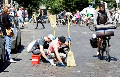 Vecinos de Hamburgo limpian las calles despu&eacute;s de los destrozos causados por las protestas del G-20. 