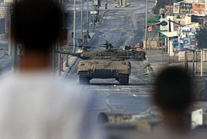 Dos niños palestinos observan un tanque israelín ayer en Belén.