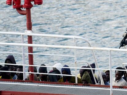 Un policía armado vigila a un grupo de inmigrantes a bordo del barco petrolero El Hiblu 1, en el Gran Puerto de La Valeta (Malta).