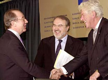 Rato (izquierda) y Duisenberg se saludan en presencia de Solbes, ayer antes de la rueda de prensa en Francfort.