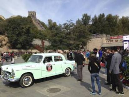 Varias personas observan un Fenghuang 760, de 1973, al pie de la Muralla China, donde coleccionistas de vehículos de época y vendedores de este tipo de autos iniciaron este fin de semana en un viaje de 1.600 kilómetros entre las dos principales ciudades de China, Pekín y Shanghái, con el que quieren fomentar la afición a los grandes clásicos del motor en el país asiático.