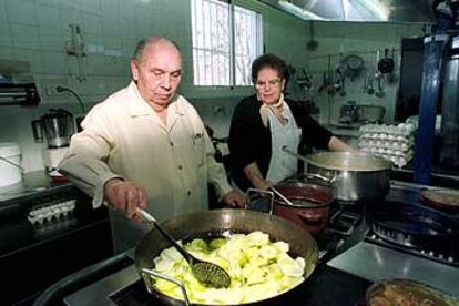 Juan Salcedo y Luisa Martínez, en la cocina del restaurante Juanito, en Baeza (Jaén). Abajo, un plato de gachas.