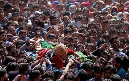 La madre de Nasarullah Mir, sobre el cuerpo sin vida de su hijo mientras varias personas lo portan durante su funeral en la ciudad de Hajin, en el área del norte del distrito de Bandipora, a 30 kilómetros de Srinagar, la capital de verano de Cachemira (India). Al menos dos militantes y dos comandos de las fuerzas aéreas indias fallecieron durante un tiroteo en Rakh (Paribal).