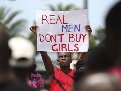 Um homem levanta um cartaz onde se lê "os homens de verdade não compram meninas", em um protesto em Lagos contra Boko Haram.