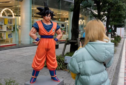 Un transeúnte tomaba fotografías de una estatua de Son Goku, personaje de 'Dragon Ball' creado por el artista de manga japonés Akira Toriyama, frente a Bandai Co. en Tokio, Japón, este viernes.