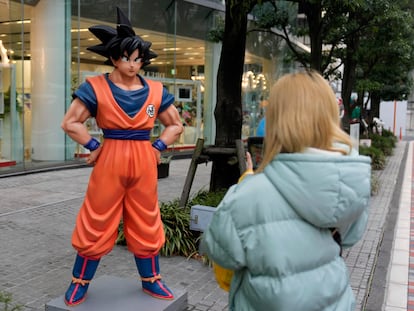 Un transeúnte tomaba fotografías de una estatua de Son Goku, personaje de 'Dragon Ball' creado por el artista de manga japonés Akira Toriyama, frente a Bandai Co. en Tokio, Japón, este viernes.