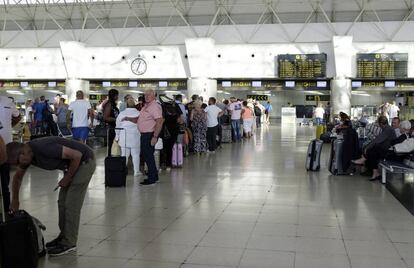 Pasajeros reubicados de la aerolínea británica Monarch, con destino a Birminghan, hacen cola en el aeropuerto de Gran Canaria para facturar en un vuelo de los denominados de "rescate" y operado por la canadiense Air Transat.