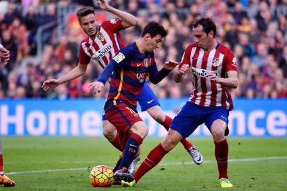 Messi controla el balón entre Saúl y Godín.