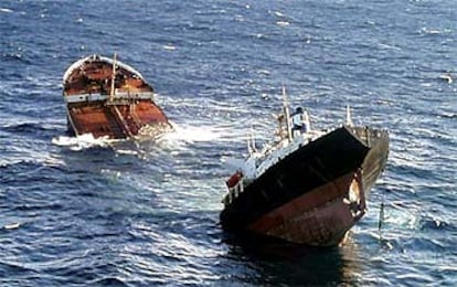 El petrolero <b></b><i>Prestige,</i> abierto por una de sus planchas y roto en dos, se hunde frente a las costas gallegas.