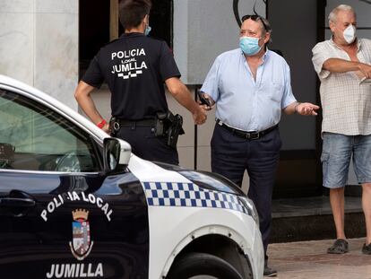 Un agente de la Policía Local de Jumilla (Murcia) pide la documentación a dos hombres, este jueves.