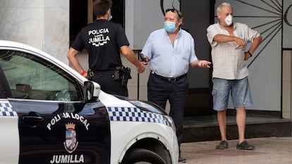 Un agente de la Policía Local de Jumilla (Murcia) pide la documentación a dos hombres, este jueves.