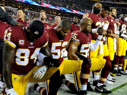 Jugadores del Washington Redskins se arrodillan durante el himno antes de un partido contra los Oakland Raiders.