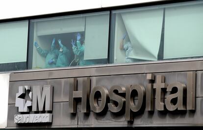 Varios sanitarios saludan desde el Hospital de La Paz, en Madrid.