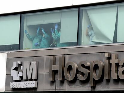 Varios sanitarios saludan desde el Hospital de La Paz, en Madrid.