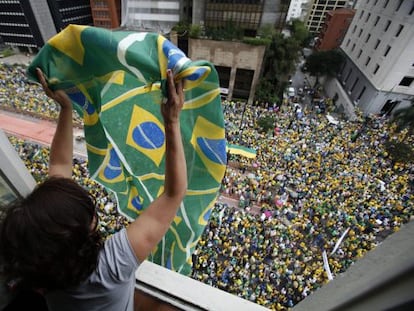 Mulher agita bandeira para manifestantes.