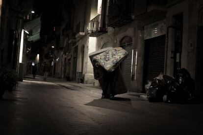 Un hombre arrastra colchones en Barcelona.
