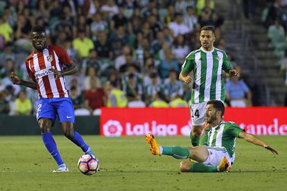 El jugador del Real Betis, Cejudo (d) se se lanza para cortar un pase del jugador del Atlético de Madrid, Thomas (i).