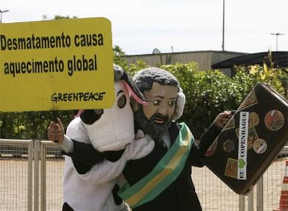 Unos activistas de Greenpeace parodian el próximo viaje de Lula a Copenhague, con pancartas que alertan del riesgo de la deforestación.