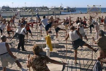 Un grupo de ancianos practica gimnasia en la playa de Benidorm.