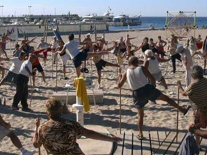 Un grupo de ancianos practica gimnasia en la playa de Benidorm.