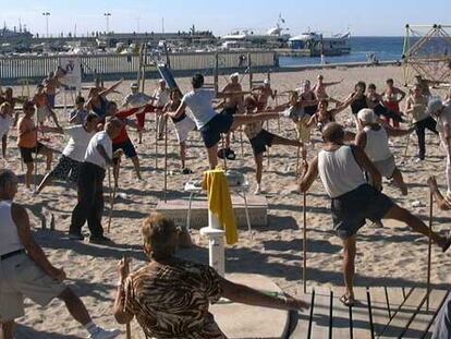 Un grupo de ancianos practica gimnasia en la playa de Benidorm.